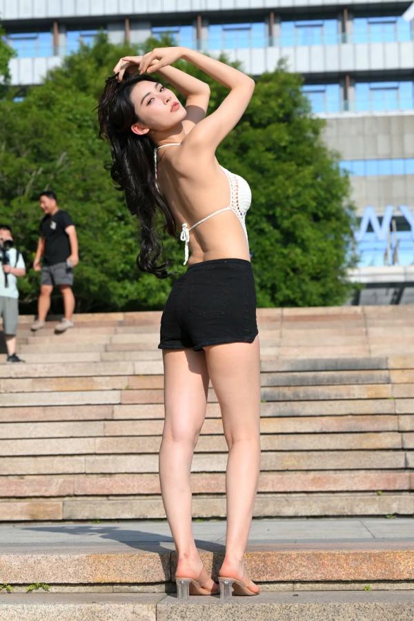    街拍女神白色露背镂空上衣搭配黑色短裤，都市喷泉旁展现曼妙曲线与修长美腿 [108P]第72张图片