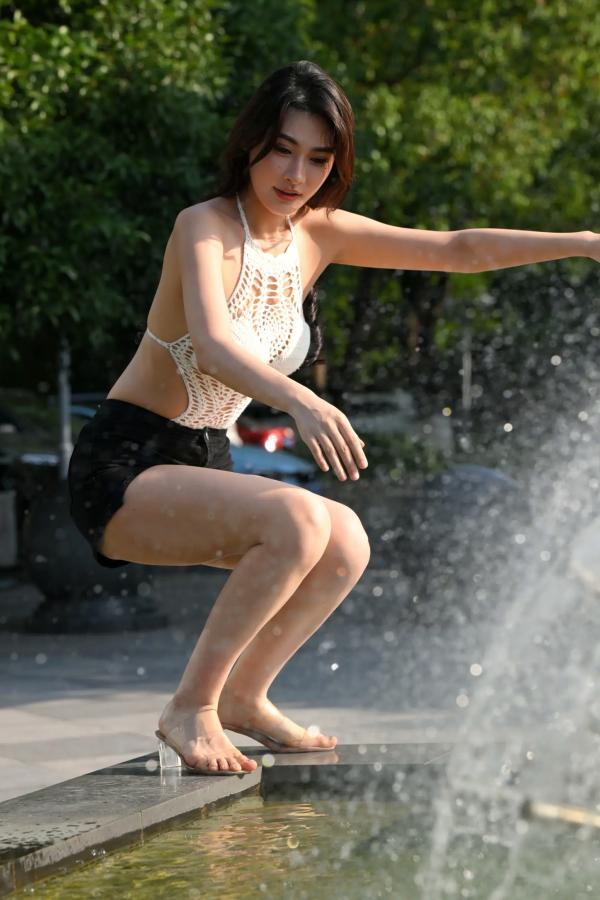    街拍女神白色露背镂空上衣搭配黑色短裤，都市喷泉旁展现曼妙曲线与修长美腿 [108P]第95张图片