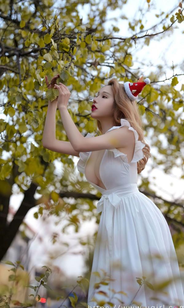 妮小妖   尤果圈妮小妖《落花之愿》户外大尺度圣诞装，白色深V长裙展现性感诱惑与傲人身材第10张图片